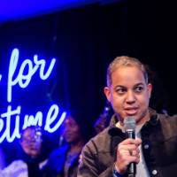 A grad speaks and cheers holding a glass